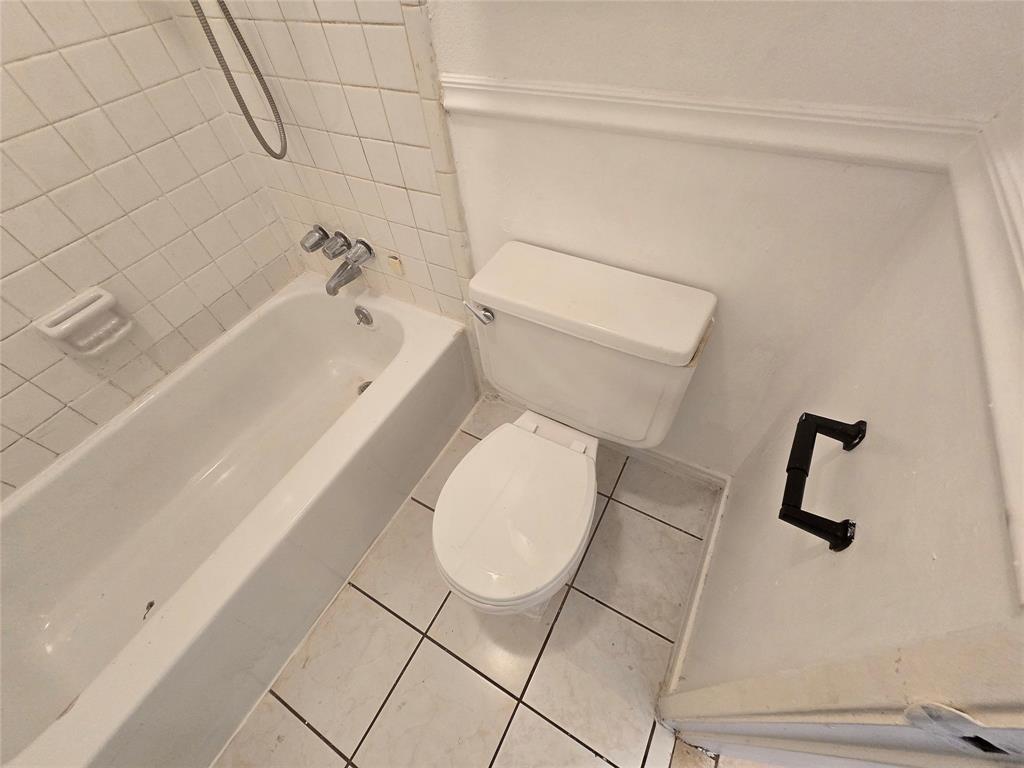 8071 Meadow Road, Unit 218 Dallas, TX 75231 - Photo 13 of 24 a bathroom with a toilet and a bath tub