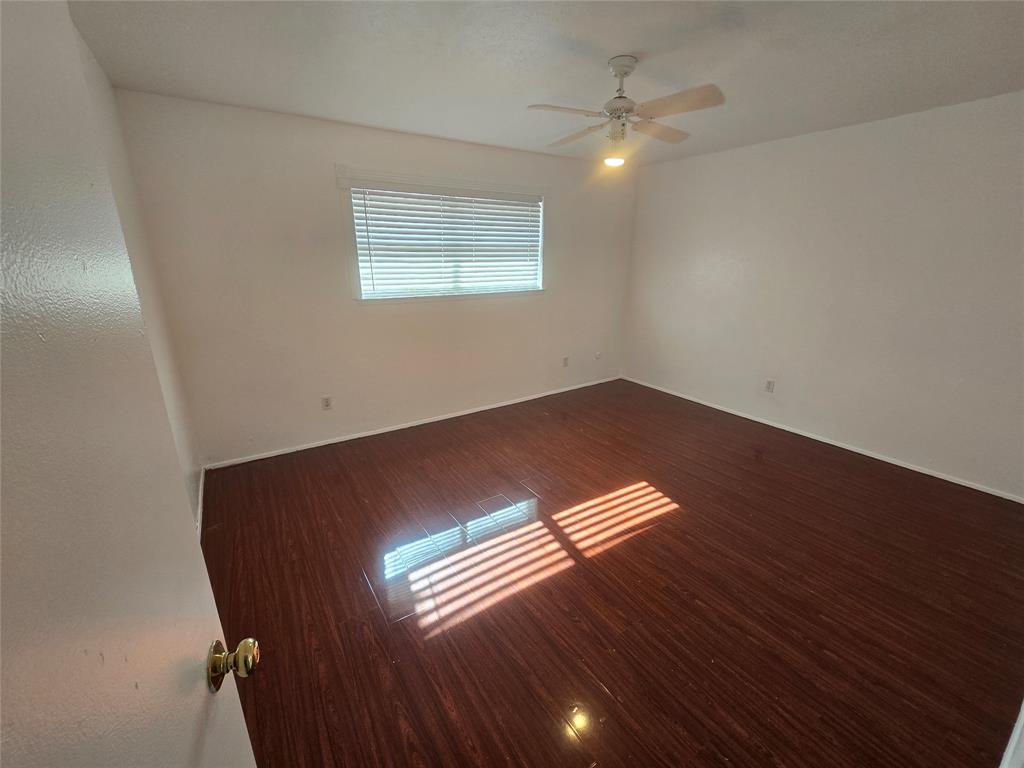 8071 Meadow Road, Unit 218 Dallas, TX 75231 - Photo 21 of 24 a view of an empty room with wooden floor and a window