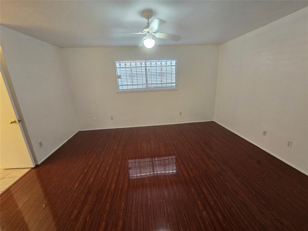 8071 Meadow Road, Unit 218 Dallas, TX 75231 - Photo 9 of 24 wooden floor in an empty room with a window
