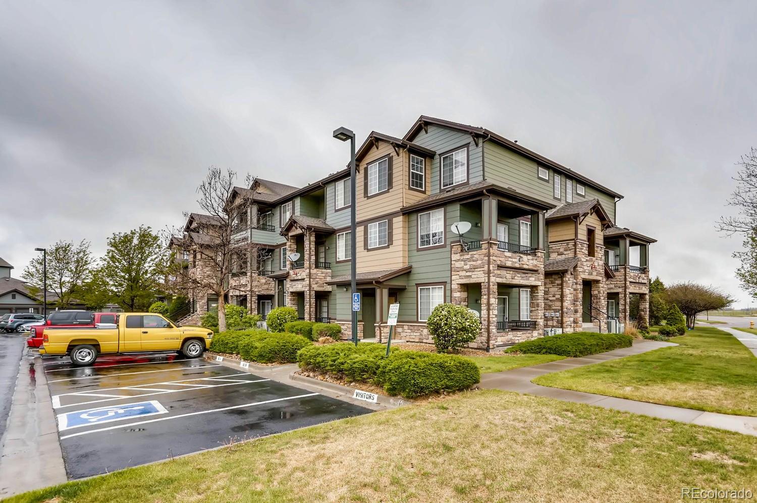 a view of a big house with cars parked