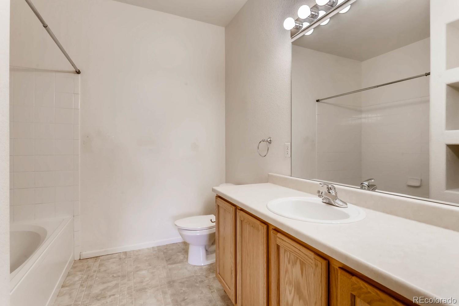 5255 Memphis Street, Unit 811 Denver, CO 80239 - Photo 11 of 12 a bathroom with a sink a toilet and shower