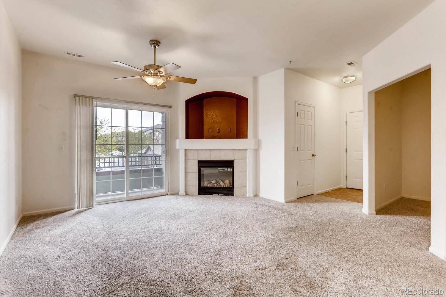 5255 Memphis Street, Unit 811 Denver, CO 80239 - Photo 2 of 12 a view of an empty room with chandelier fan and a fireplace