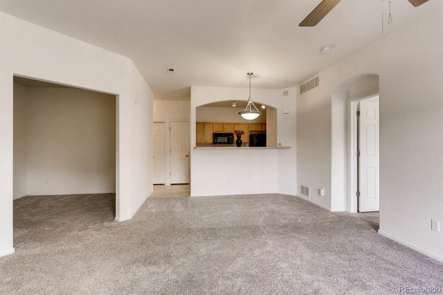 5255 Memphis Street, Unit 811 Denver, CO 80239 - Photo 3 of 12 an empty room with a kitchen and a sink