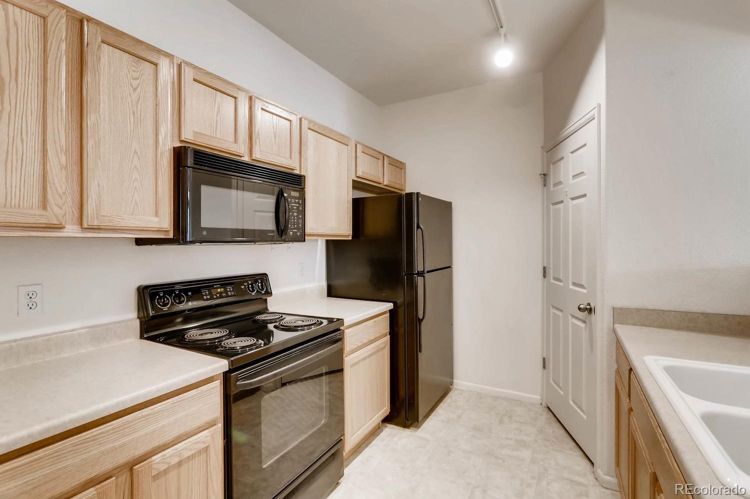 5255 Memphis Street, Unit 811 Denver, CO 80239 - Photo 5 of 12 a kitchen with stainless steel appliances a refrigerator stove and microwave