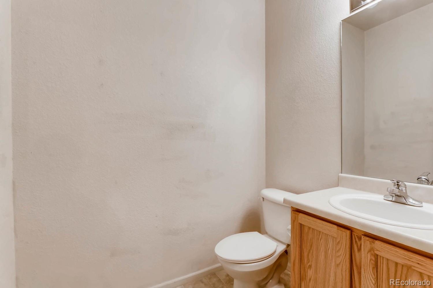 5255 Memphis Street, Unit 811 Denver, CO 80239 - Photo 8 of 12 a bathroom with a sink a toilet and a mirror