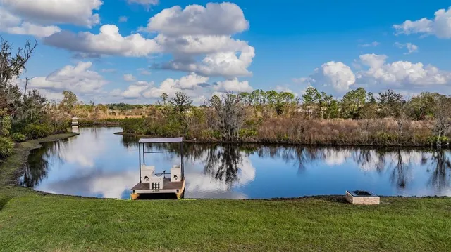 a backyard of a house with lots of green space and fountain