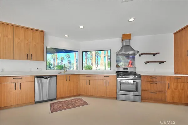 a kitchen with stainless steel appliances granite countertop a stove and white cabinets