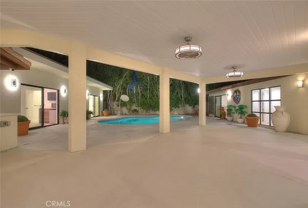 a view of an empty room with glass door and a chandelier
