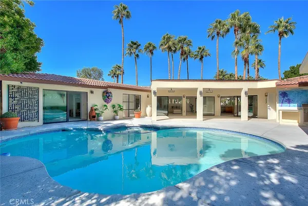 an aerial view of a house with a swimming pool patio and outdoor seating