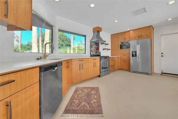 a kitchen with stainless steel appliances granite countertop a refrigerator sink and stove