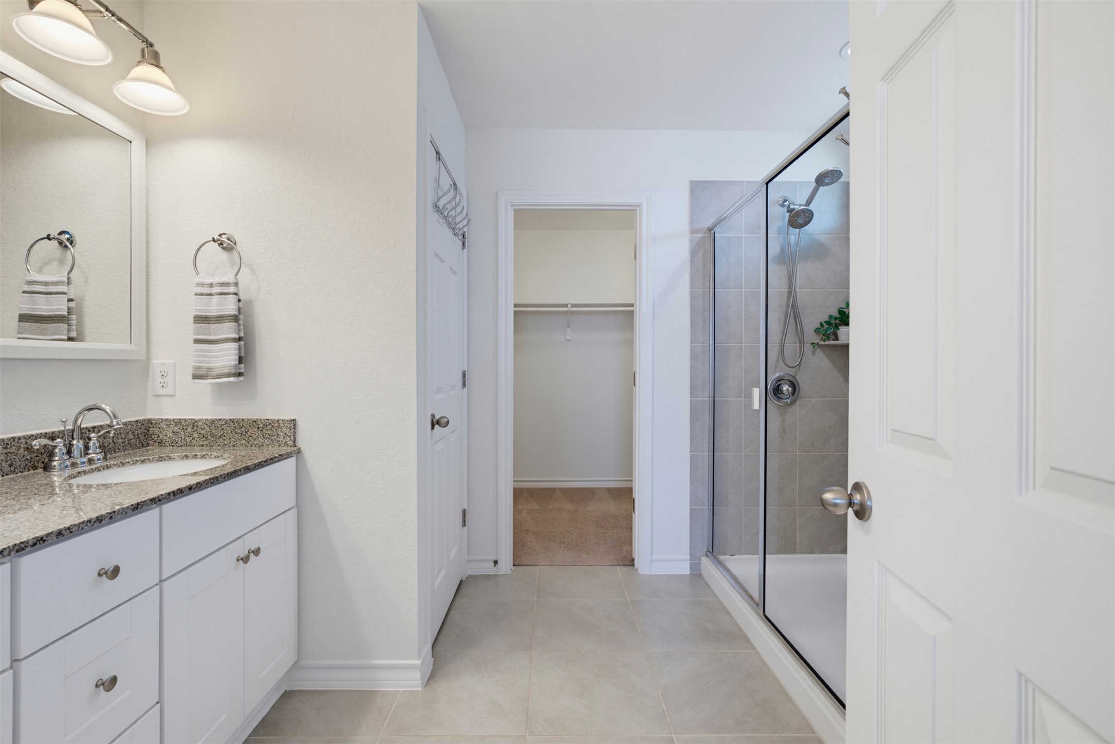 11008 Players Path Austin, TX 78747 - Photo 13 of 26 Tiled flooring and a walk-in closet highlight this functional primary bathroom layout.