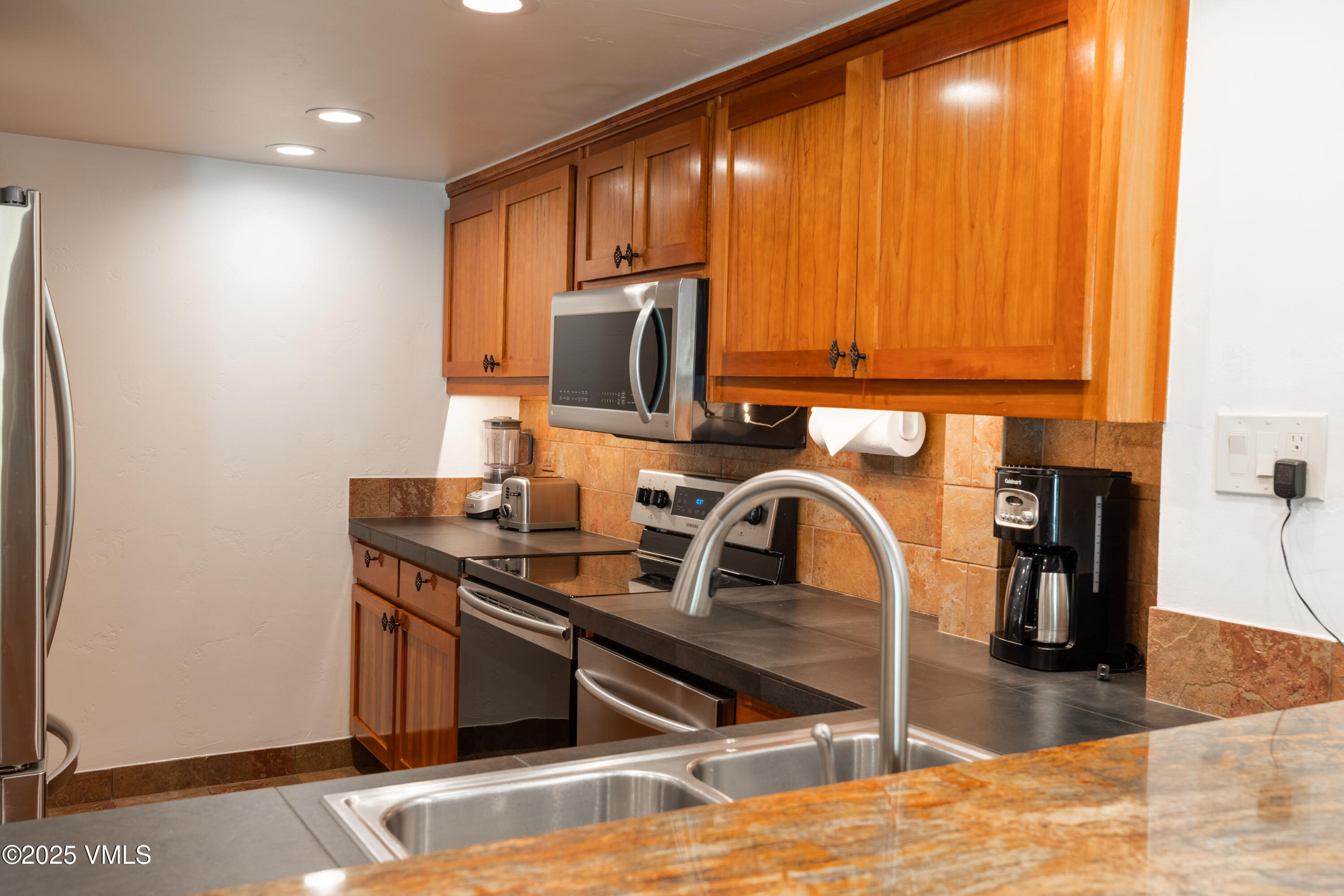 390 East Lionshead Circle, Unit 103 Vail, CO 81657 - Photo 7 of 22 a kitchen with a sink a stove and a microwave