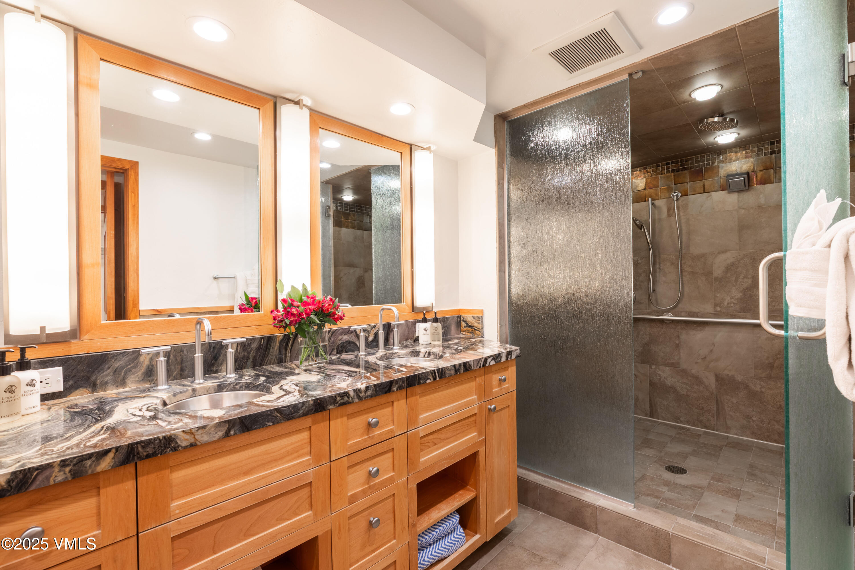 390 East Lionshead Circle, Unit 103 Vail, CO 81657 - Photo 10 of 22 a bathroom with a shower sink double and mirror