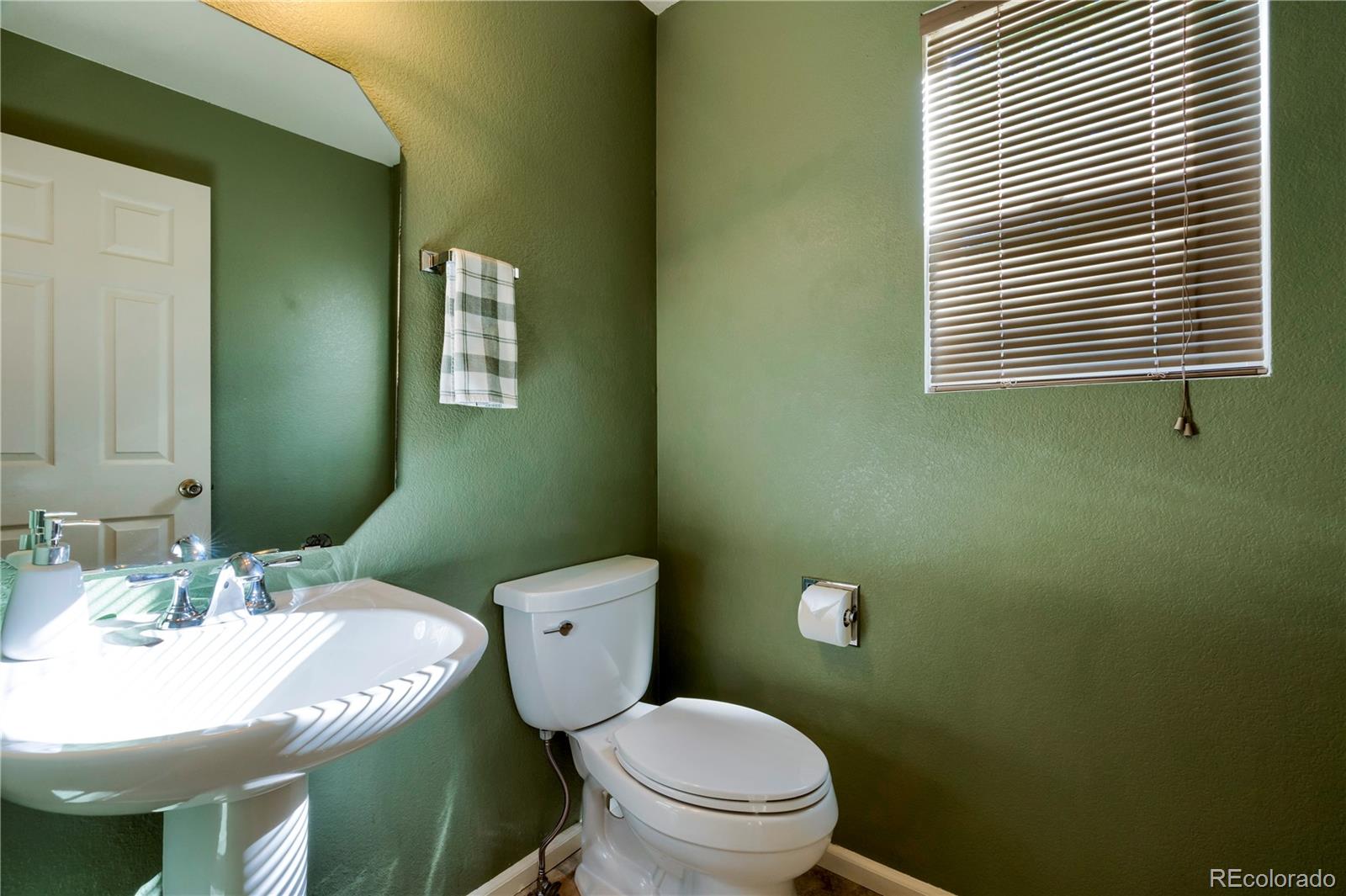 1290 Trail Ridge Road Longmont, CO 80504 - Photo 17 of 38 a bathroom with a sink a toilet and mirror