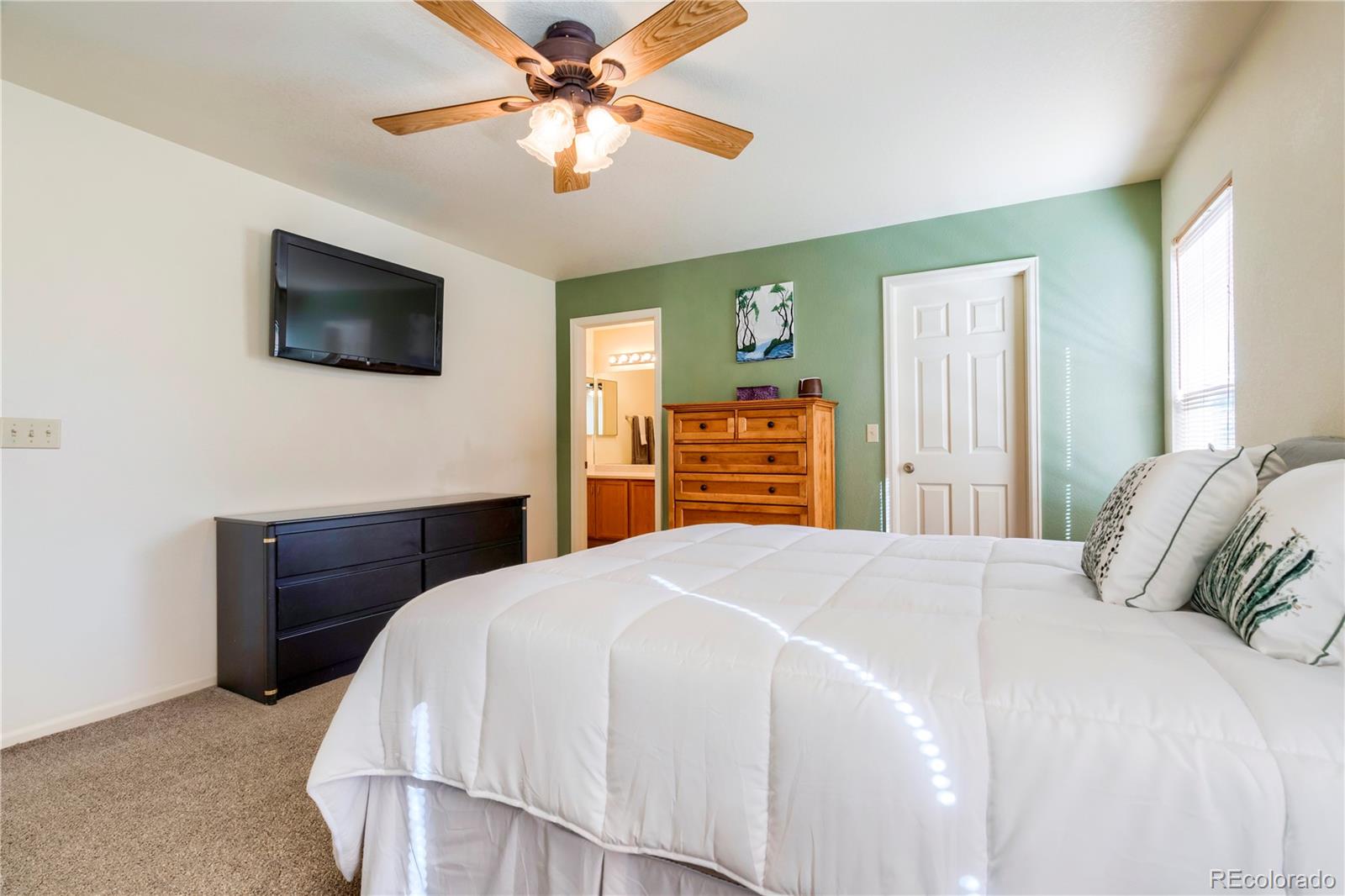 1290 Trail Ridge Road Longmont, CO 80504 - Photo 20 of 38 a bedroom with a bed and a flat screen tv