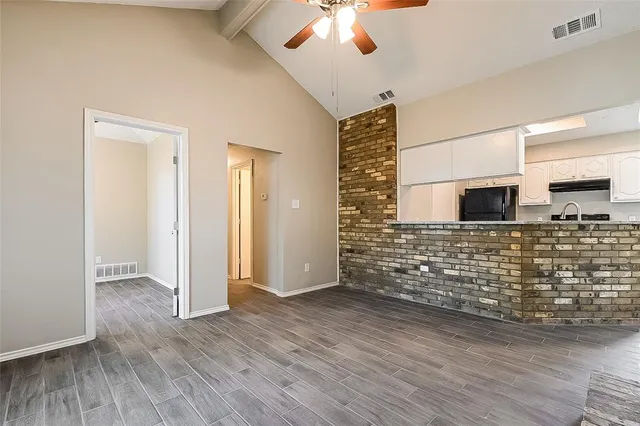 a view of empty room with wooden floor