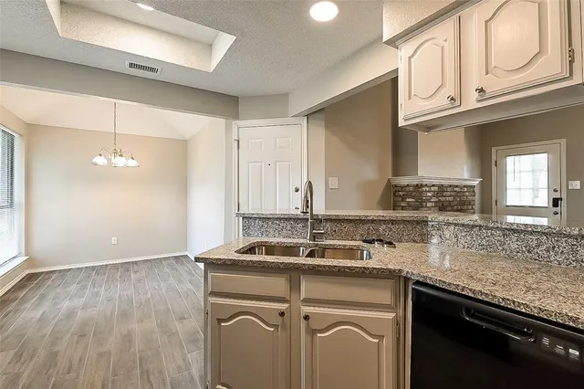 a kitchen with stainless steel appliances granite countertop a sink stove and cabinets