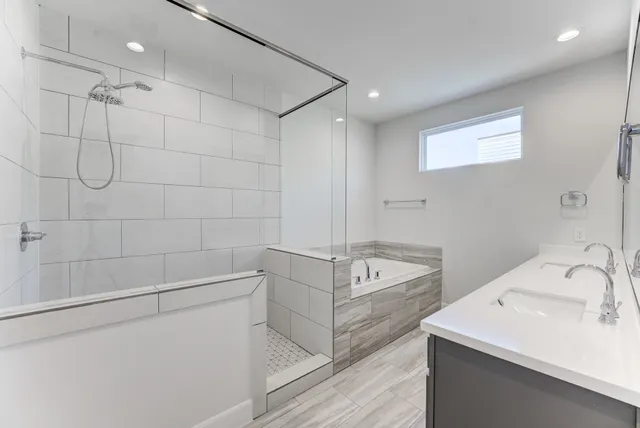 a bathroom with a tub a sink and mirror