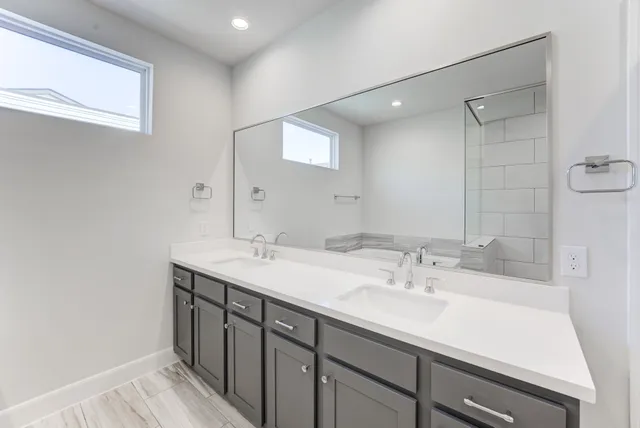 a bathroom with a sink double vanity and a mirror