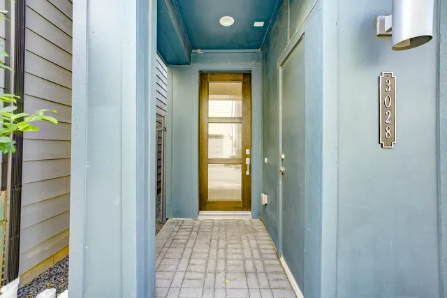 a view of a hallway with wooden floor and a bathroom