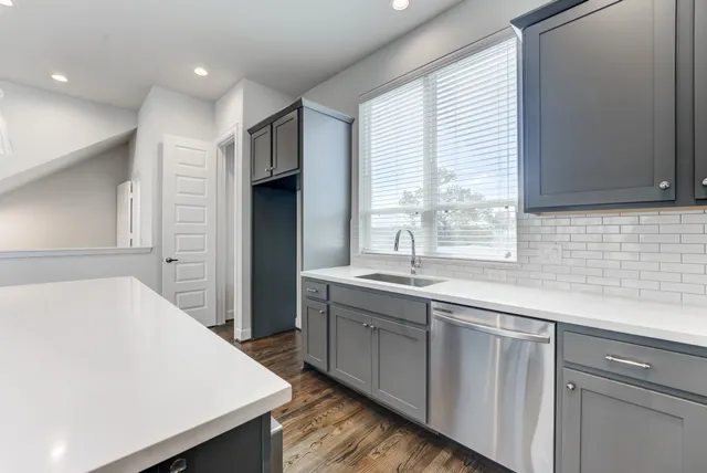 a kitchen with a sink a window and cabinets