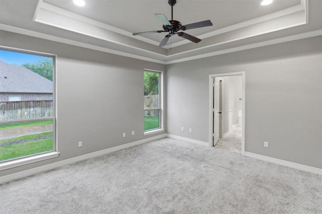 7765 Hickory Spring Lane Tyler, TX 75703 - Photo 22 of 38 Spacious room featuring tray ceilings with recessed lighting, a ceiling fan, and plush carpeting