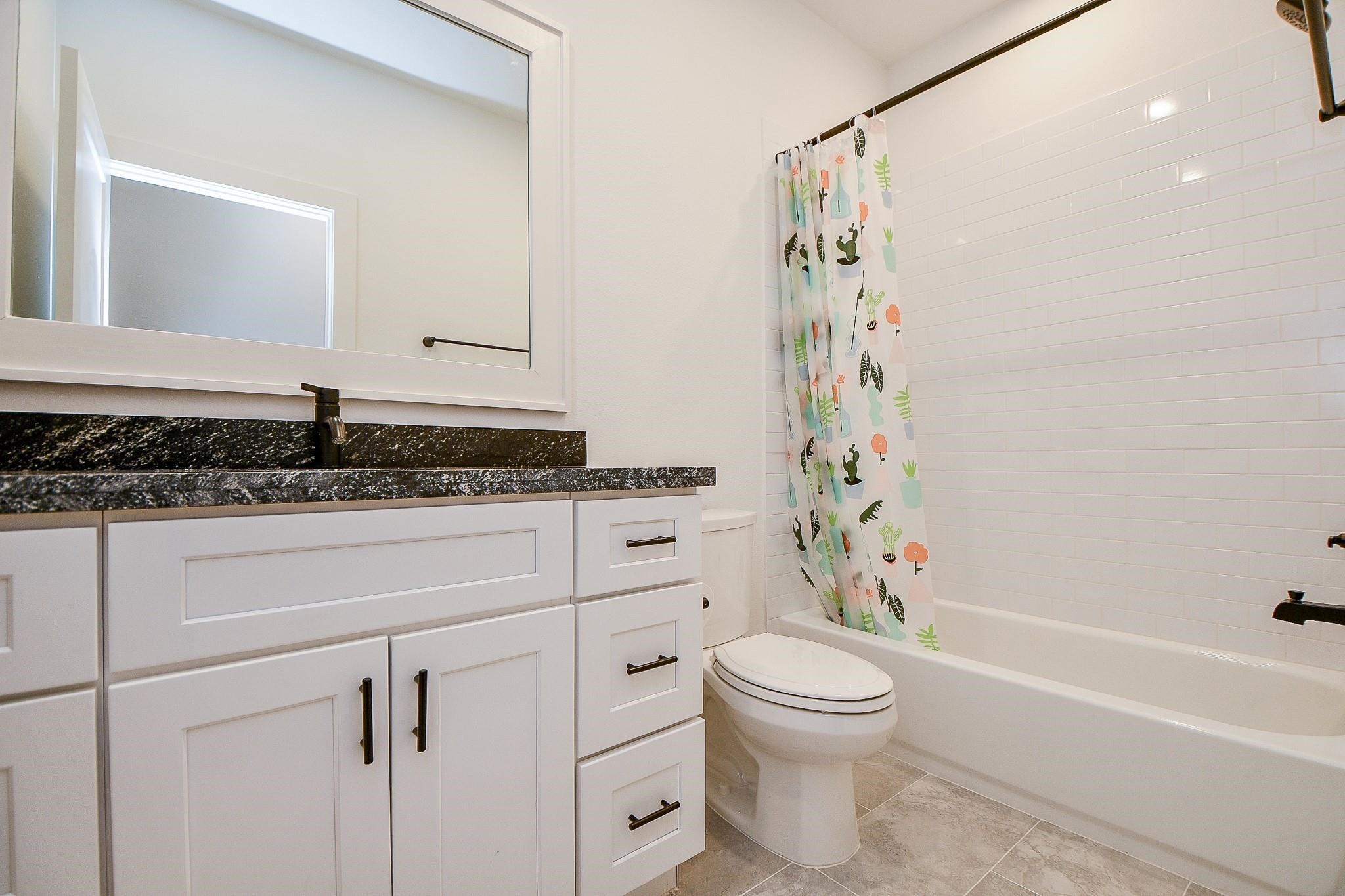 4403 Greeley Street Houston, TX 77006 - Photo 25 of 28 a bathroom with a granite countertop sink a toilet and shower