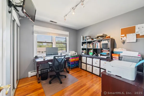 a view of a livingroom with workspace and a window