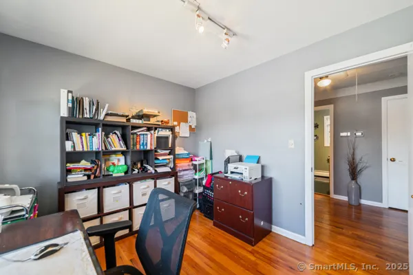 a living room with furniture a bookshelf and a window