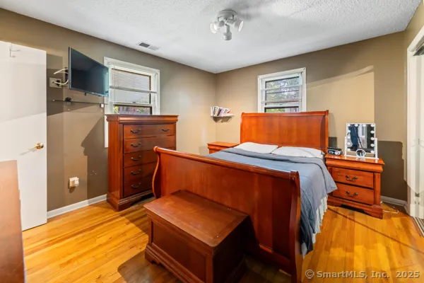a bedroom with a bed and wooden floor