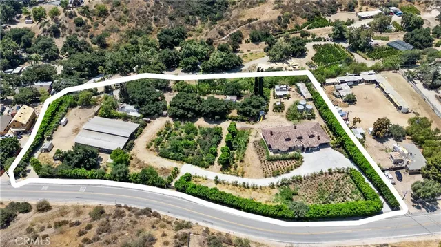 an aerial view of a house with yard and mountain view in back