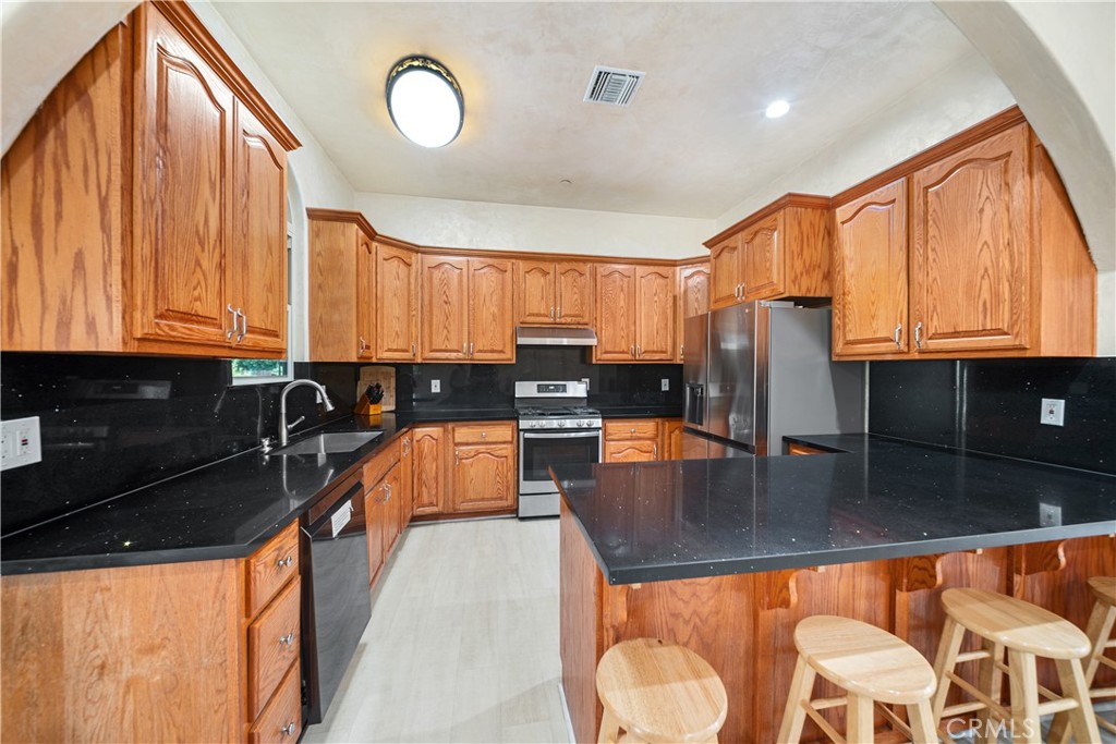 12605 Kagel Canyon Road Sylmar, CA 91342 - Photo 15 of 61 a kitchen with stainless steel appliances granite countertop a stove a sink and a microwave