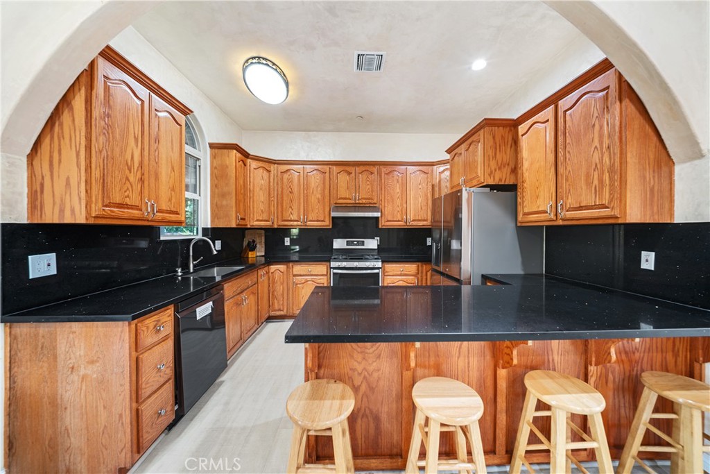 12605 Kagel Canyon Road Sylmar, CA 91342 - Photo 16 of 61 a kitchen with stainless steel appliances granite countertop a stove a sink and a microwave