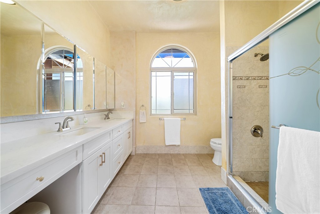 12605 Kagel Canyon Road Sylmar, CA 91342 - Photo 22 of 61 a spacious bathroom with a double vanity sink a mirror and a shower