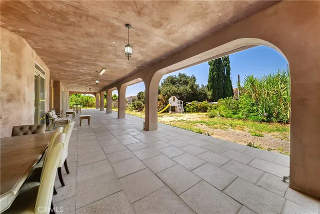 a kitchen with stainless steel appliances kitchen island granite countertop a stove a refrigerator a sink a dining table and chairs with wooden floor