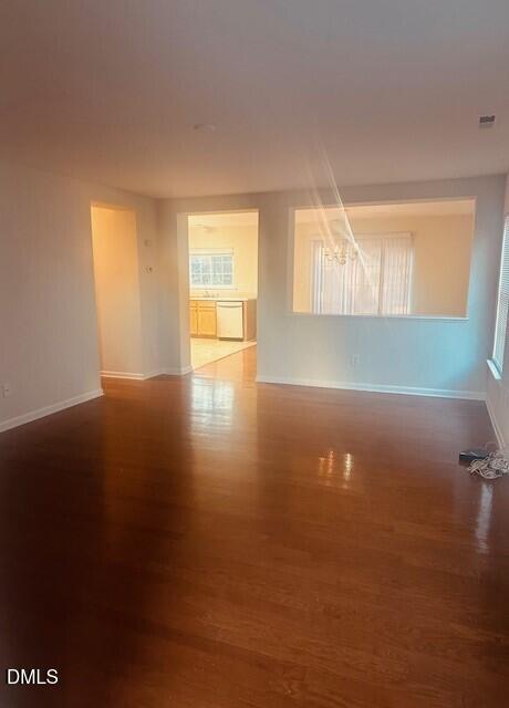 6005 Namozine Court Raleigh, NC 27610 - Photo 2 of 24 an empty room with wooden floor and windows with curtains