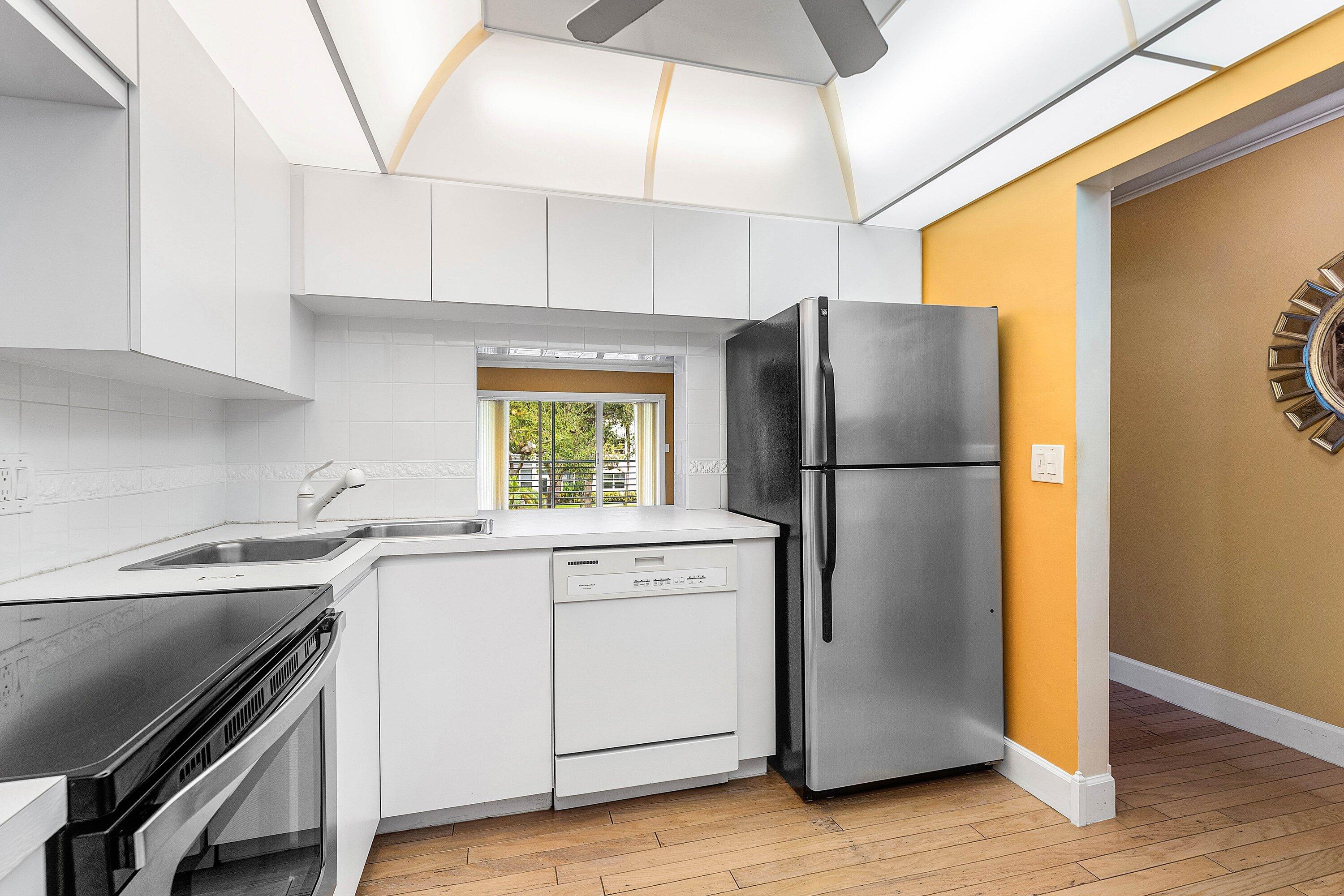 1501 South Ocean Boulevard, Unit 225 Lauderdale-by-the-Sea, FL 33062 - Photo 8 of 47 a kitchen with a refrigerator sink stove and cabinets