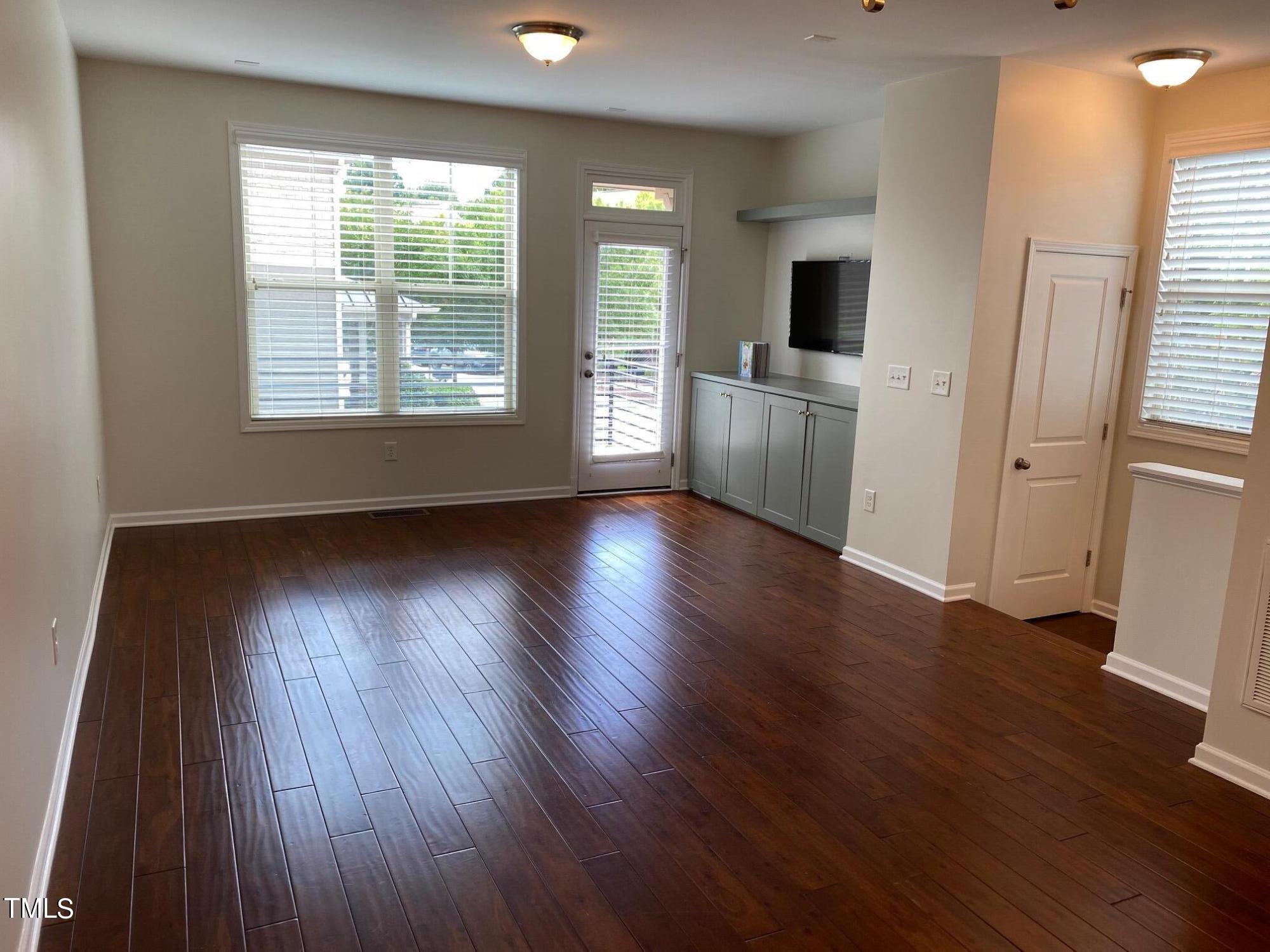 1571 Rodessa Run Raleigh, NC 27607 - Photo 3 of 25 an empty room with wooden floor and windows