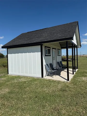 a backyard of a house with wooden fence and a bench