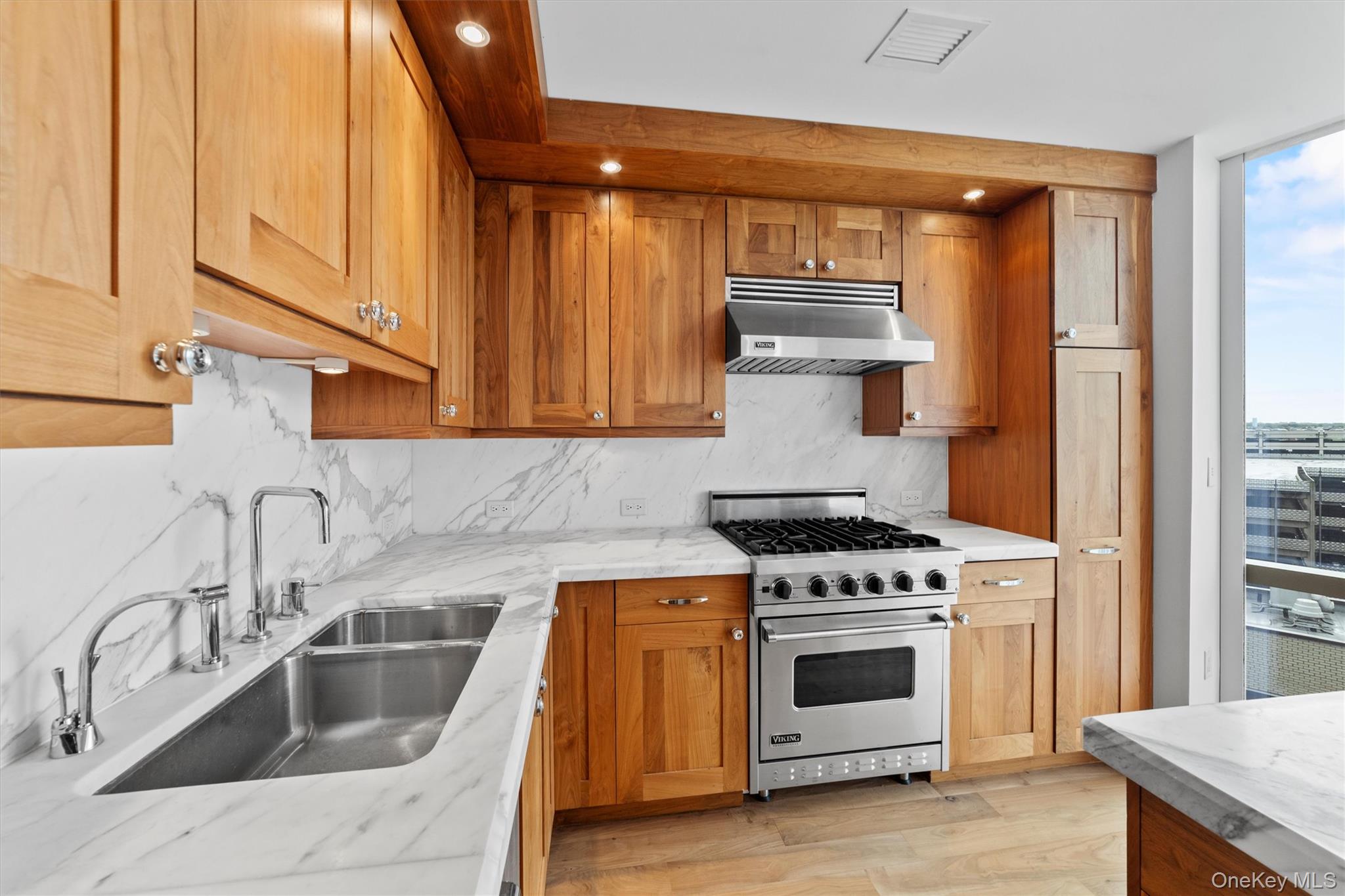 5 Renaissance Square, Unit 10G White Plains, NY 10601 - Photo 11 of 28 a kitchen with white cabinets and appliances