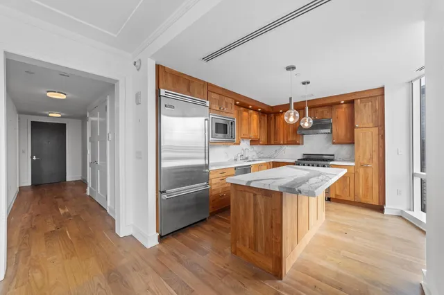 a kitchen with stainless steel appliances granite countertop a refrigerator a sink and a stove