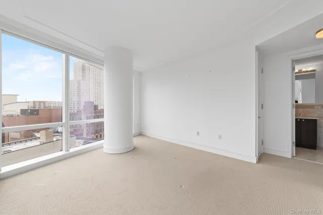 en empty room with large windows and city view
