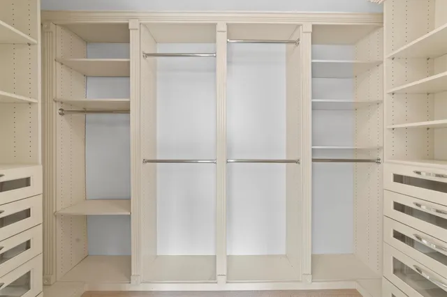a view of walk in closet with empty racks
