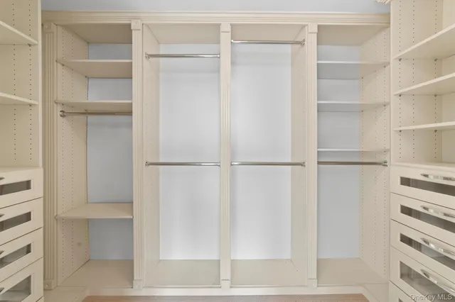 a view of walk in closet with empty racks