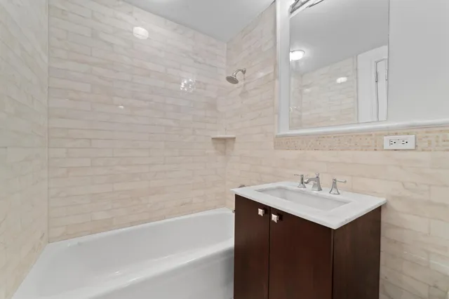 a bathroom with a sink mirror and a bathtub