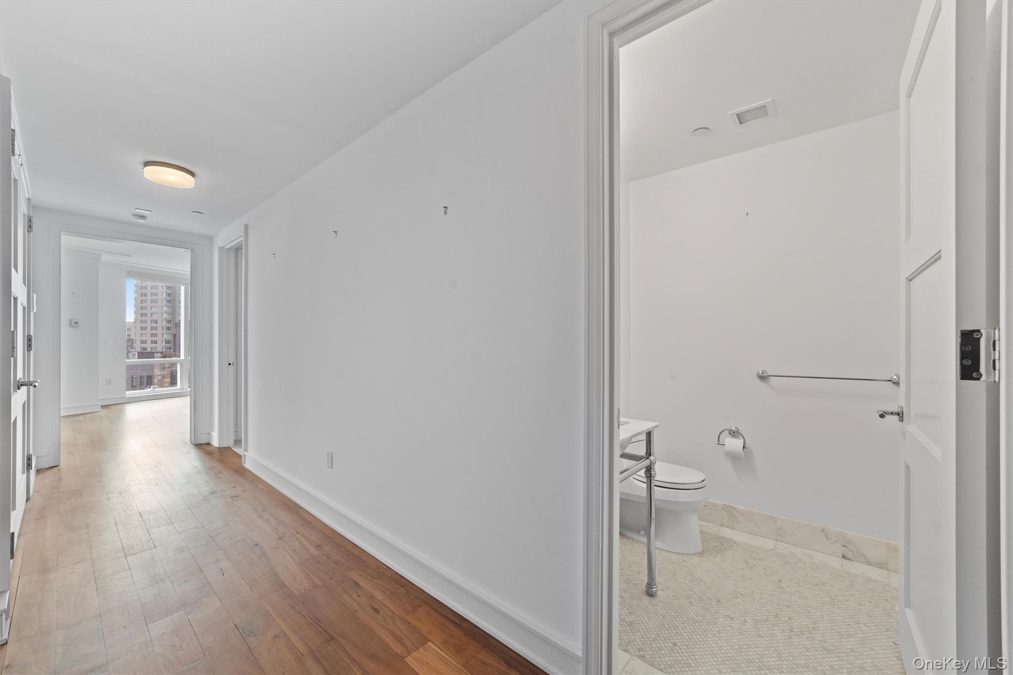 5 Renaissance Square, Unit 10G White Plains, NY 10601 - Photo 3 of 28 a view of a hallway with wooden floor