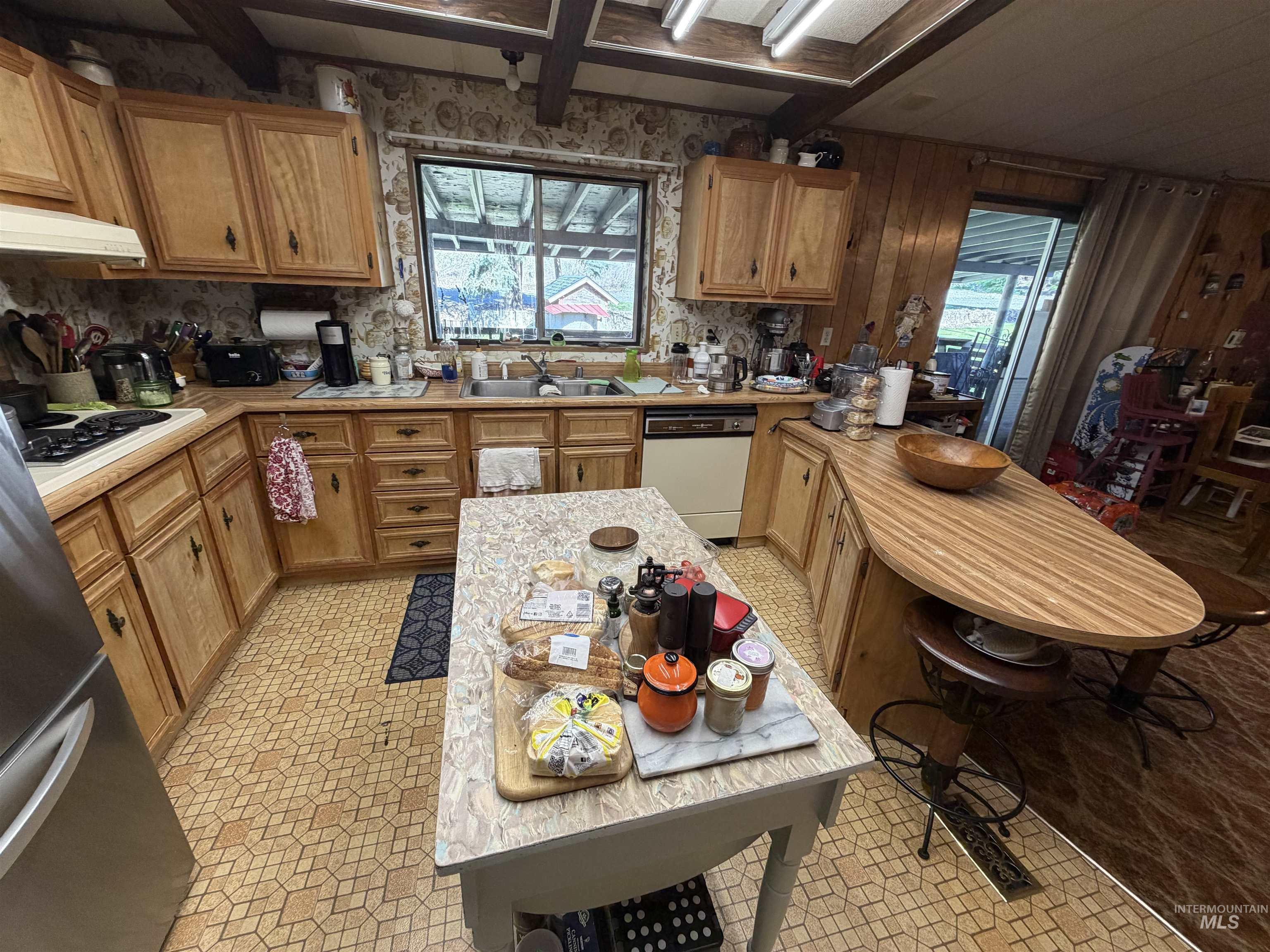 27474 North Tom Beall Road Lapwai, ID 83540 - Photo 40 of 50 Kitchen featuring light countertops, a peninsula, dishwasher, plenty of natural light, and beam ceiling