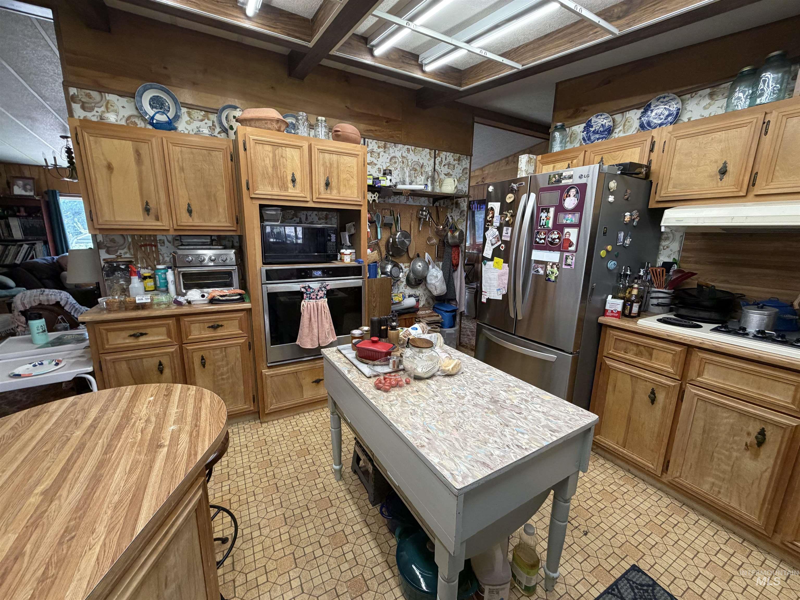 27474 North Tom Beall Road Lapwai, ID 83540 - Photo 42 of 50 Kitchen featuring light countertops, stainless steel appliances, wooden walls, and wood finish cabinetry