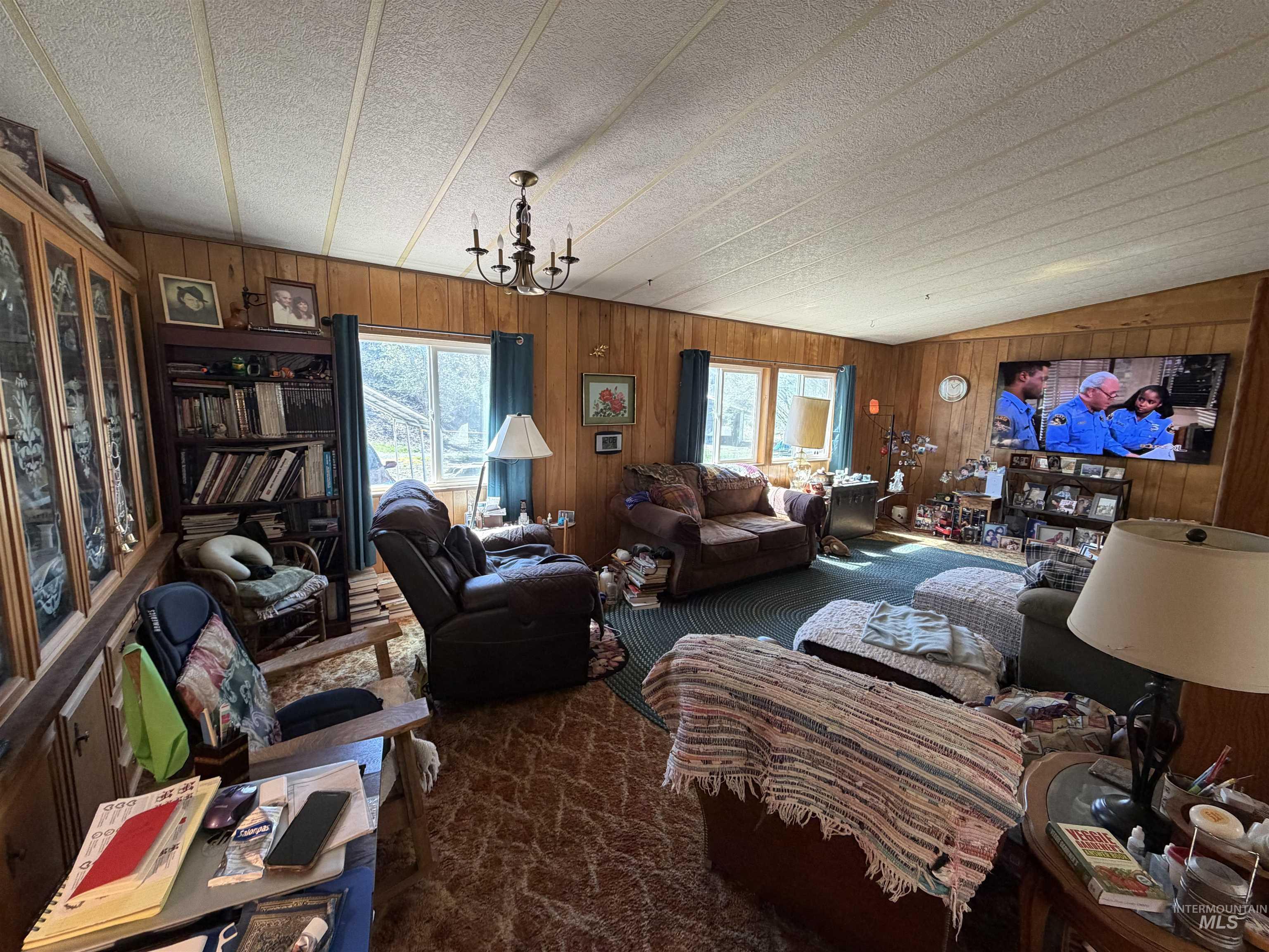 27474 North Tom Beall Road Lapwai, ID 83540 - Photo 44 of 50 Living area featuring wood walls, carpet flooring, and suspended lighting