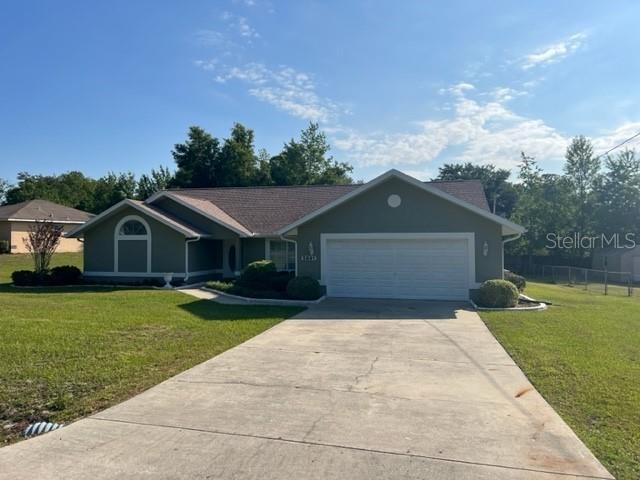 5891 Pecan Road Ocala, FL 34472 - Photo 1 of 1 a front view of a house with a yard and garage